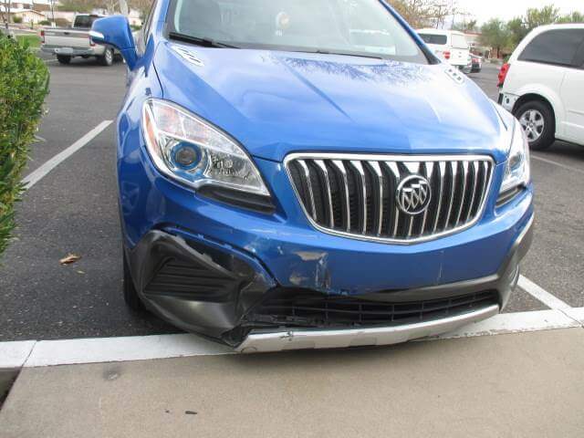 Before repair of a Buick with extensive front end damage.