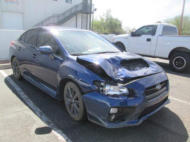 Before repair of a blue Subaru with front bumper damage.